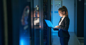 Female engineer working in server room at modern data center