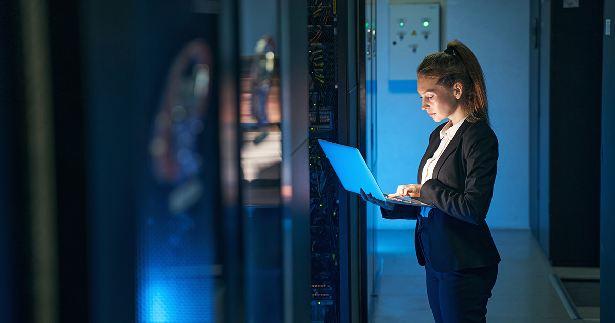 Female engineer working in server room at modern data center