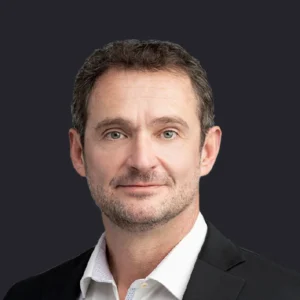 Craig Compiano, CEO in a white shirt and black blazer, stands against a dark background, reflecting leadership in data centers.