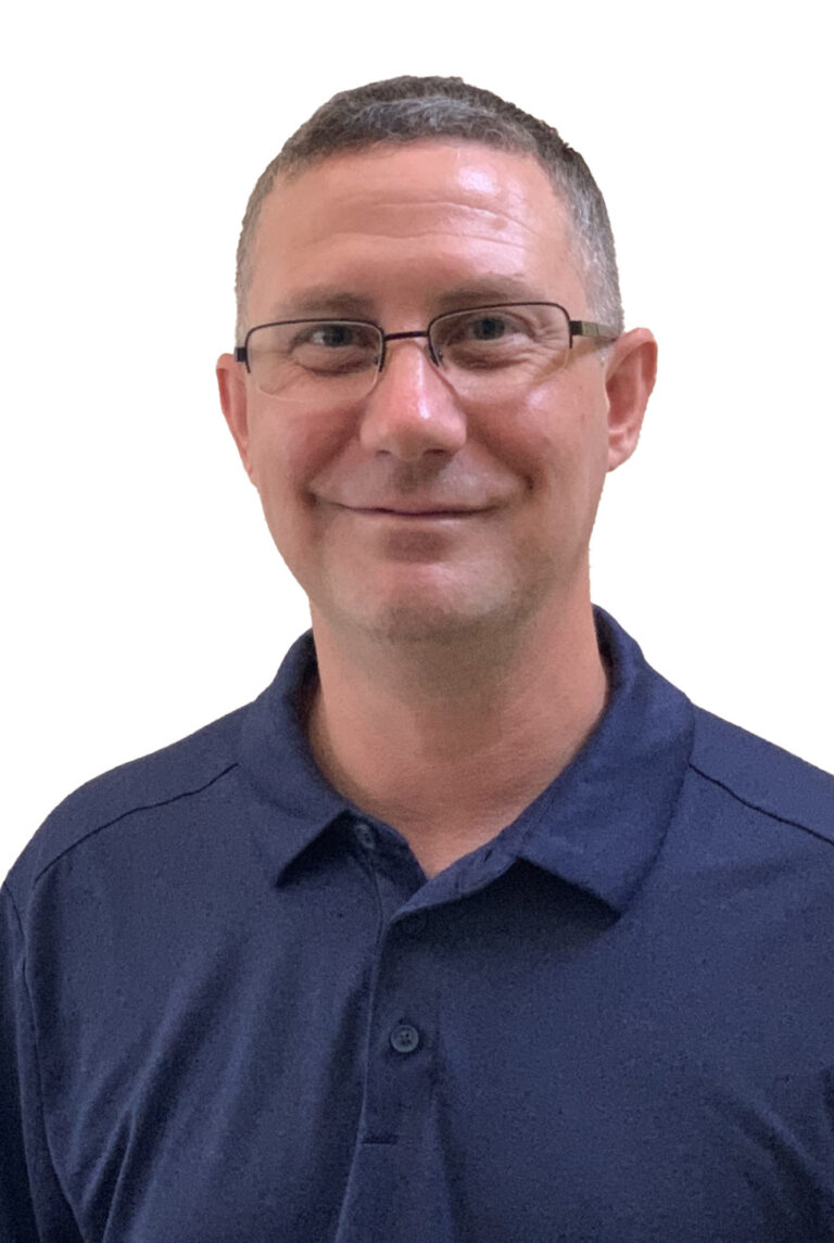 Will Strauss, with short brown hair and glasses in a navy collared shirt, smiles at the camera against a clean white background.